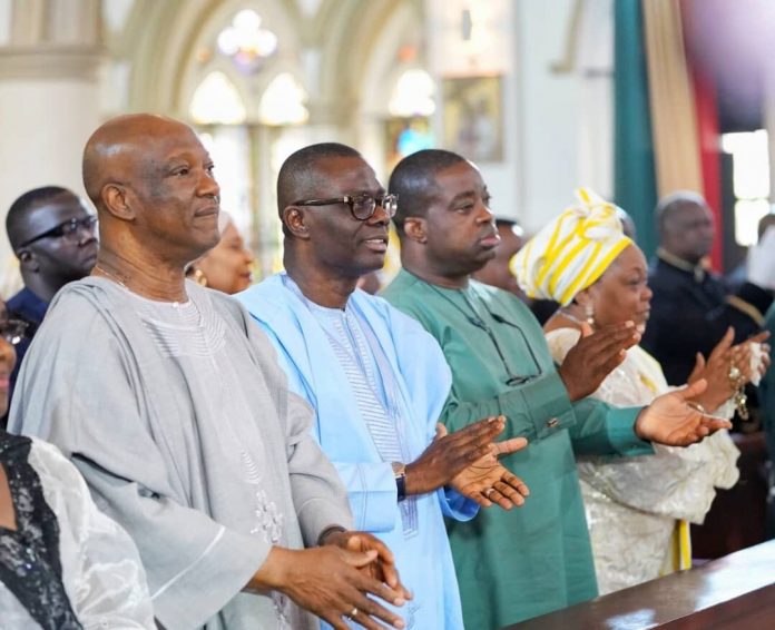 Agbaje and Sanwo-Olu clap during mass at the Holy Cross Cathedral