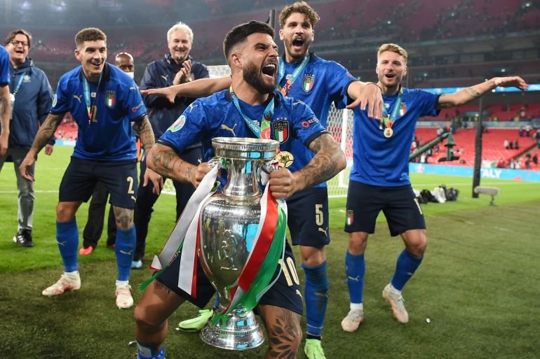 Italy's Lorenzo Insigne celebrate with the trophy after winning Euro 2020 with teammates Pool via REUTERS/Andy Rain